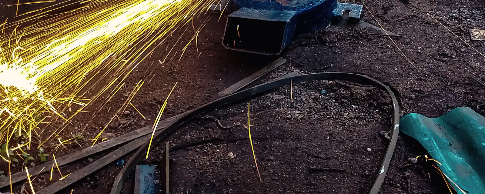 Chispas de esmerilado sobre una pieza de acero en preparación para inspección