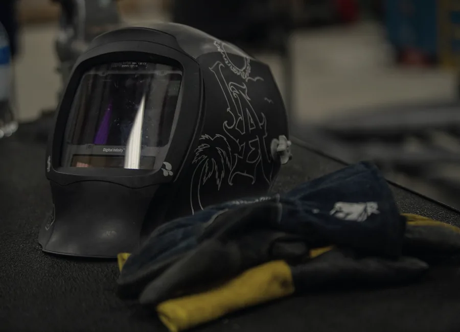 Máscara de soldar y guantes sobre el banco de trabajo de un taller